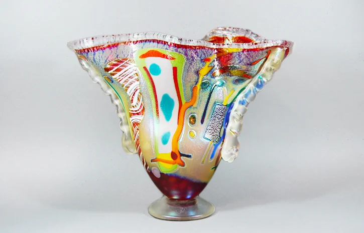 Cherry red shoulder vase with multi colored abstract design.