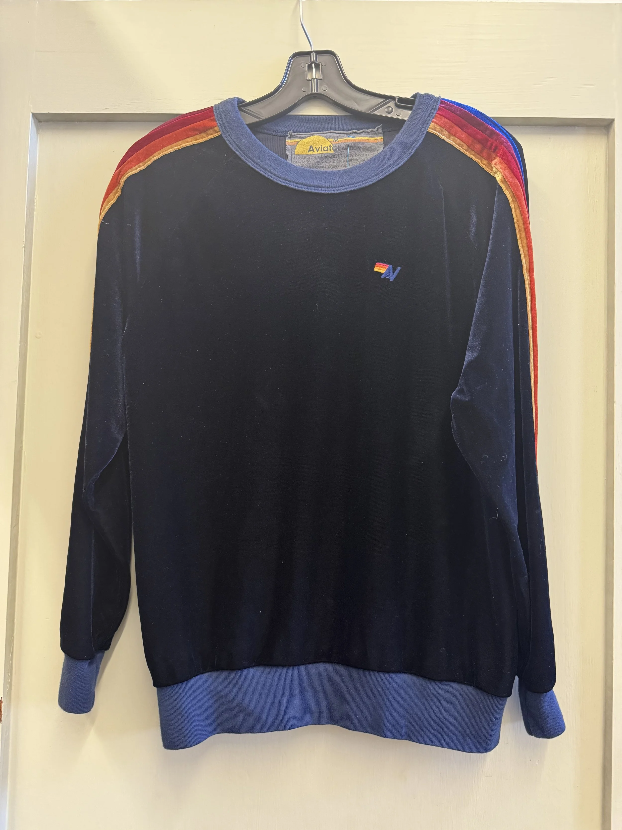 Front view of black Aviator Nation velour sweater with stripes. Logo moon front left chest