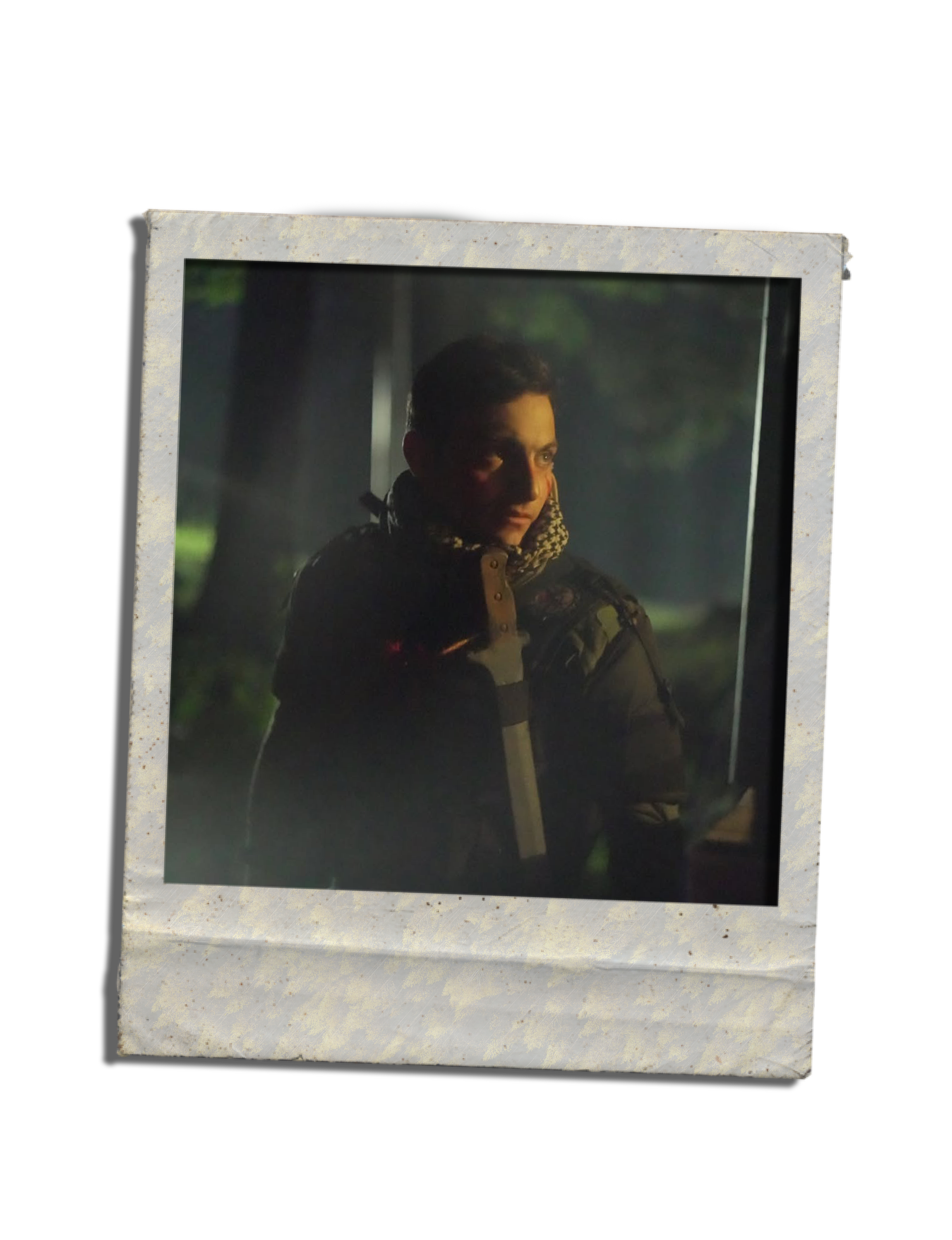 A framed photograph of a man with short dark hair, wearing a camouflage jacket, looking to the right with a serious expression, outdoors at night.