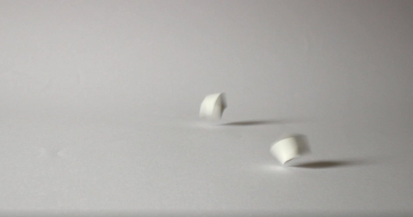  A still of  On Some Vacant and Higher Surface  showing two dice being thrown by the artist. 