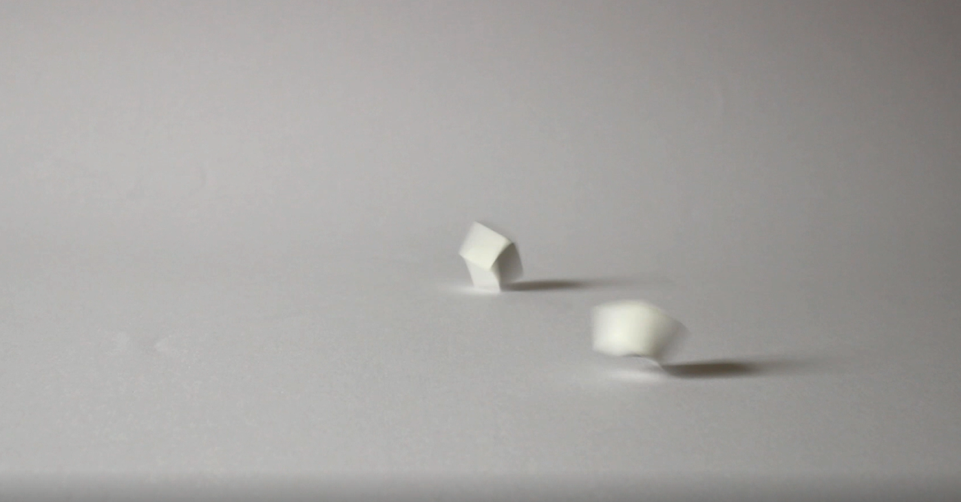  A video still of  On Some Vacant and Higher Surface  showing two dice being thrown by the artist.   Click the image to see the video. 