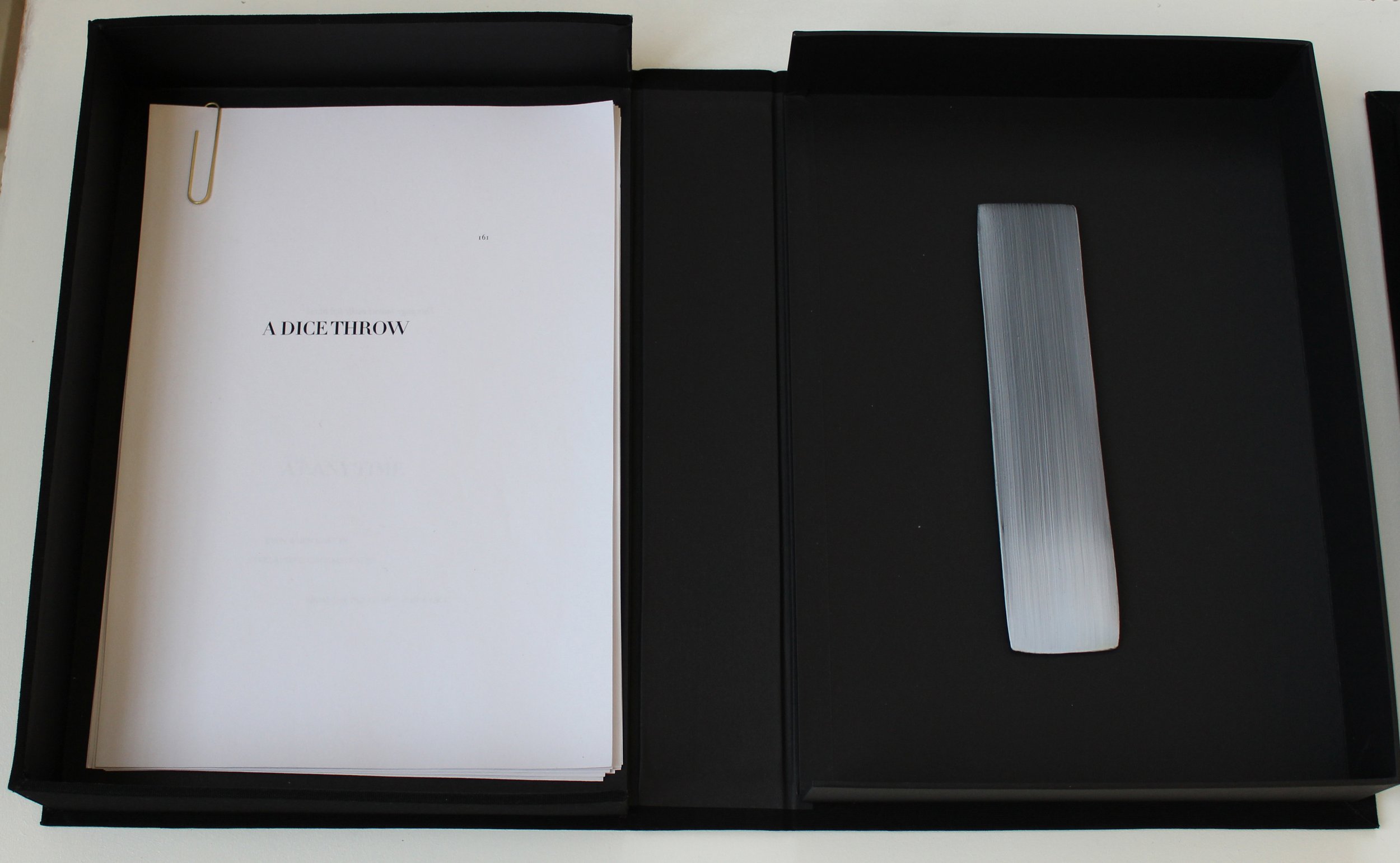  Photograph of an open black archive box displaying a translation of Mallarmé’s poem on the right. On the left, a small sculptural object or ‘brush mark’, which the artist refers to as a &nbsp;‘gesture’. 