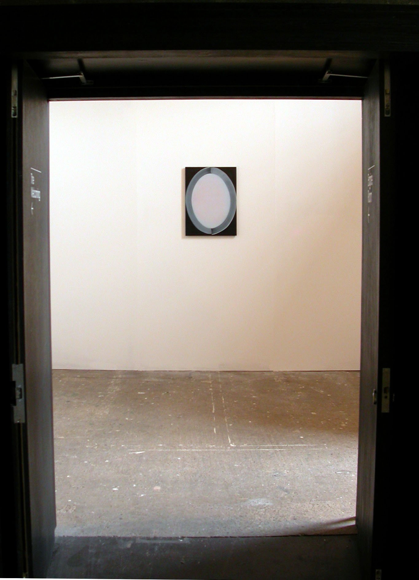  A doorway leading onto a painting installation titled  Mirror Circle Fold . On the wall opposite the doorway hangs a rectangular painting of an oval mirror. 