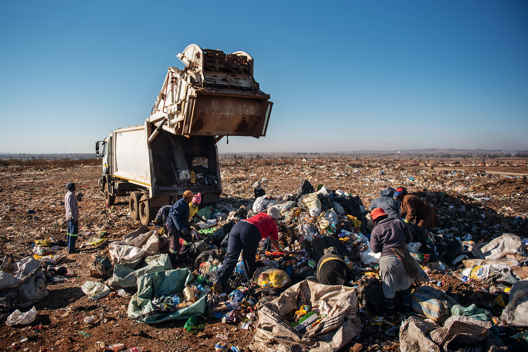 Eva Mokoena, a 33 years old South African informal waste picker, scavenges waste dumped by a garbage truck along with other women reclaimers at the Palm Springs landfill in the outskirt of Johannesburg, South Africa, on June 28, 2019.