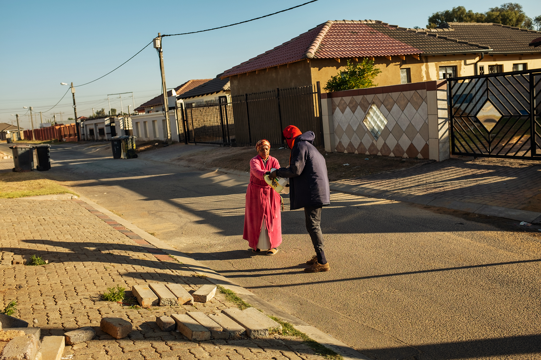 Scelo Sithole, 38, receives waste from a resident in Johannebsurg, South Africa, in the early morning of June 12, 2019.