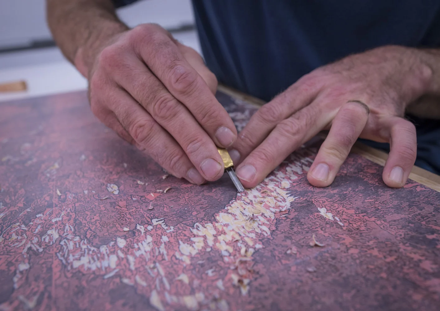 Todd Anderson, assistant professor of art and printmaking at Clemson University, carves out a “stamp” to create a reductive woodcut print of a glacier for “The Last Glacier”. (Photo by Ken Scar)
