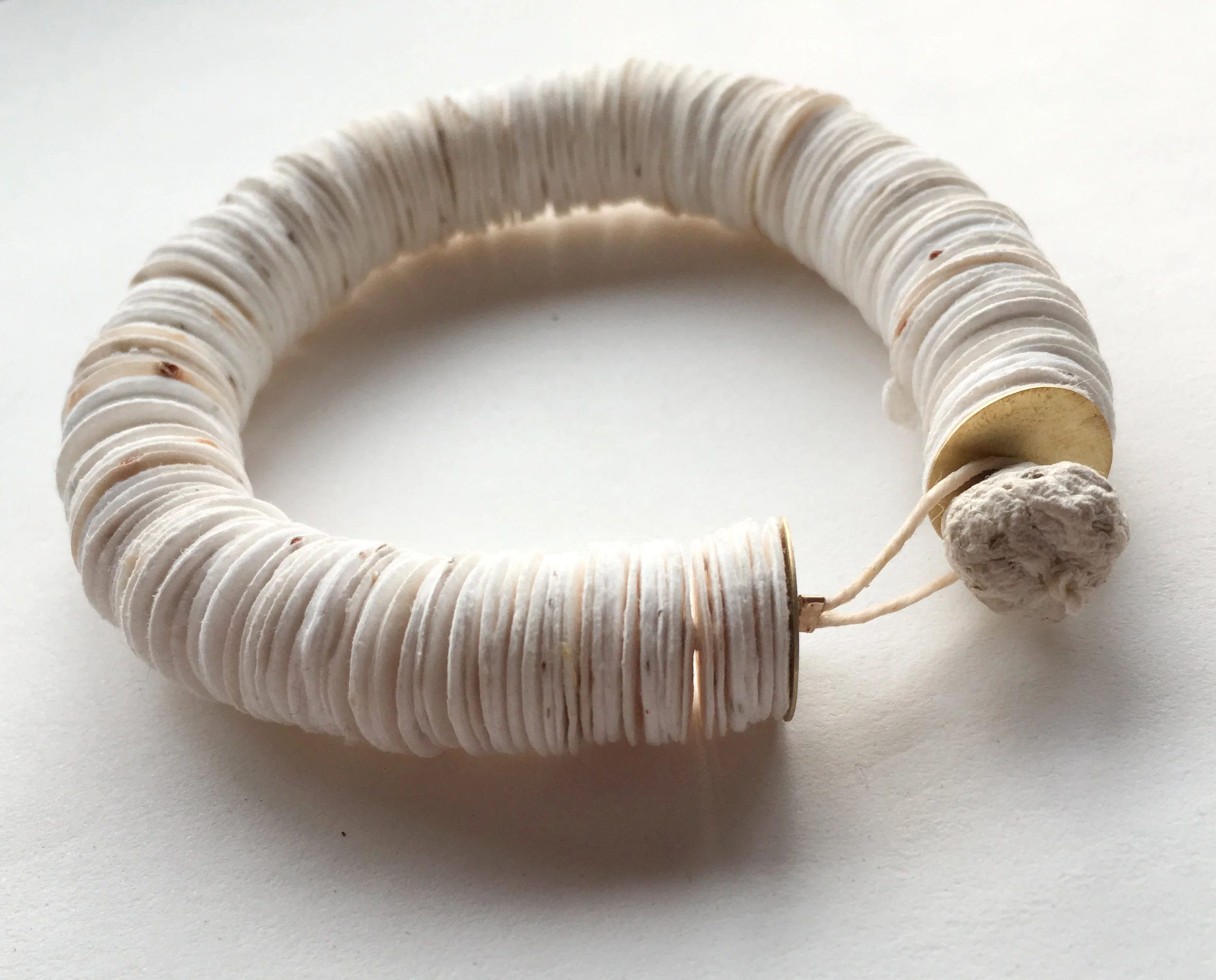  This bracelet is made of stacked handmade paper discs embedded with clover and pollinator-friendly flower seeds. The discs can be torn off and planted as you go about your day, elevating the bracelet from just a bracelet to a seed dispersal accessor