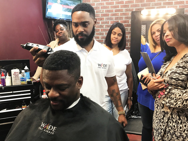 Wade Menendez resurrects a client's hair. (Maquita Peters/NPR)