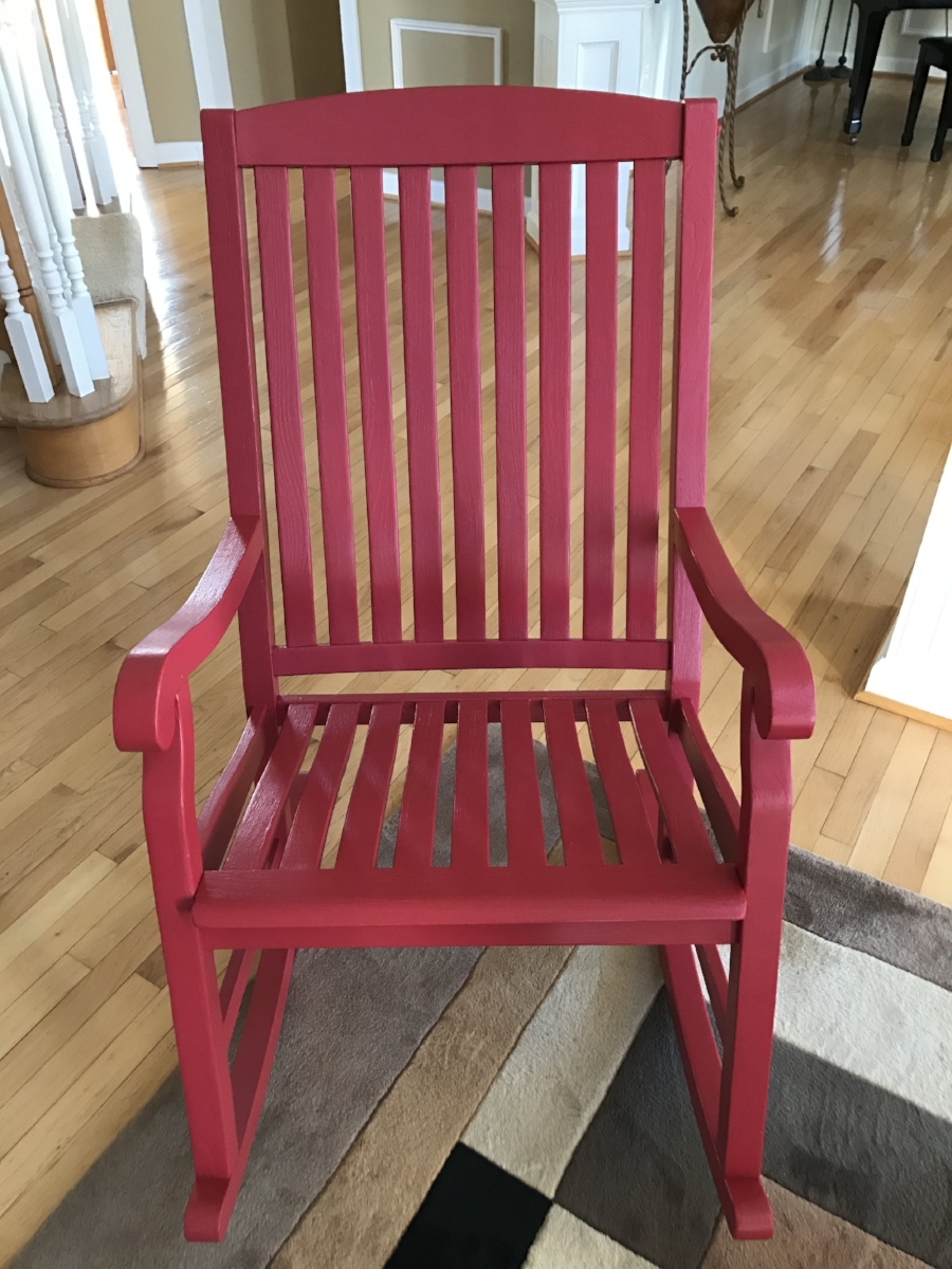 After: We sanded the old varnish off and repainted with a red stain, leaving our clients with a like new chair to relax in, and one less item in the land fill. 