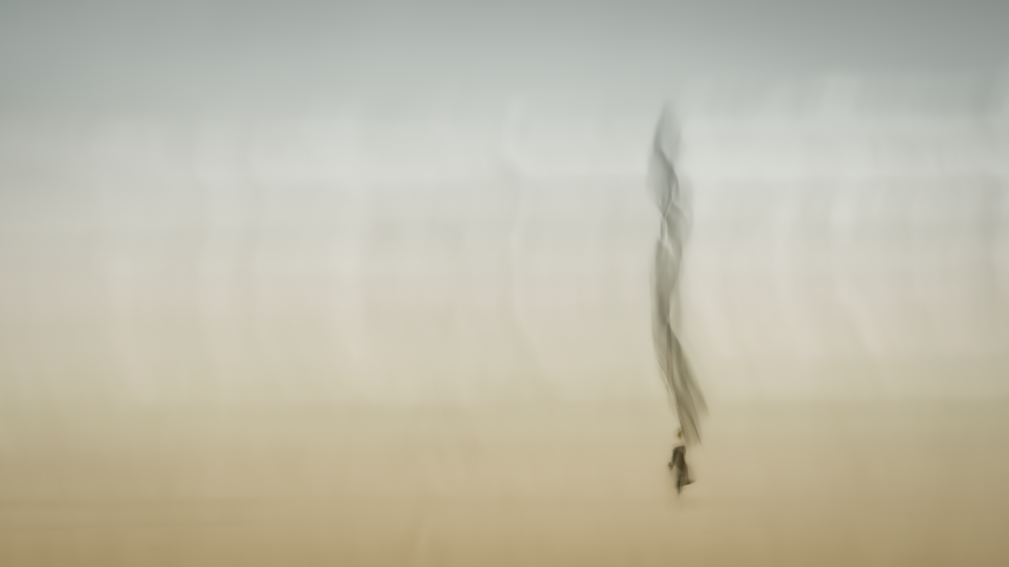 Minimalist, impressionistic ICM photograph with ghosted figure walking in beige misty atmosphere, vertical motion blur exploring emergence and solitary journey