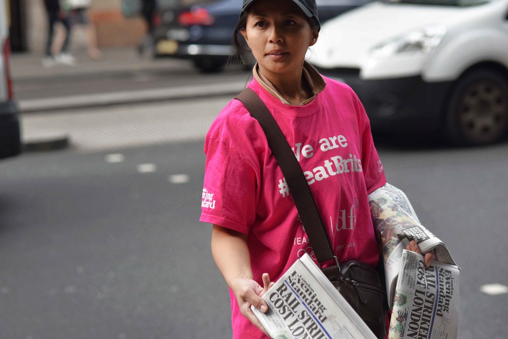 Girl selling newspaper, Kensington High Street, London, U.K. Image©thingstodot.com