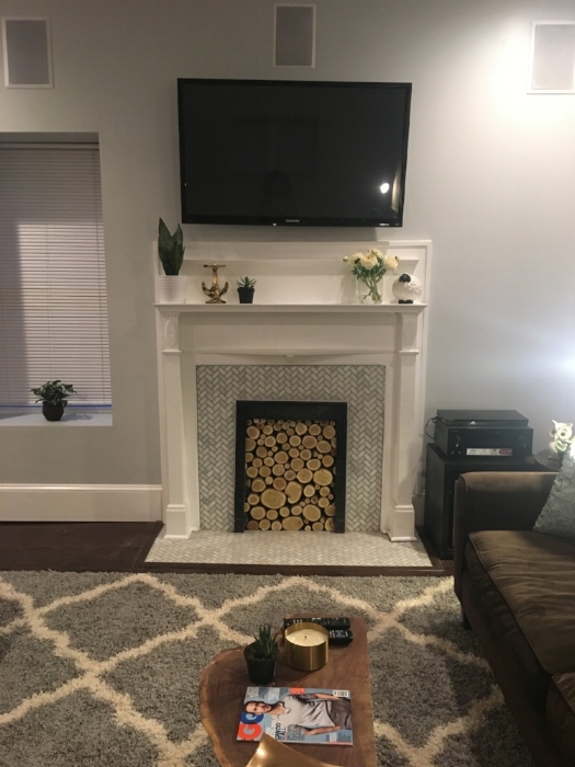 After: Fireplace with the original wood mantle and iron interior and decorative birch wood.