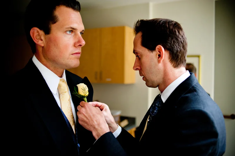 Groom applying boutonniere. Piedmont, CA