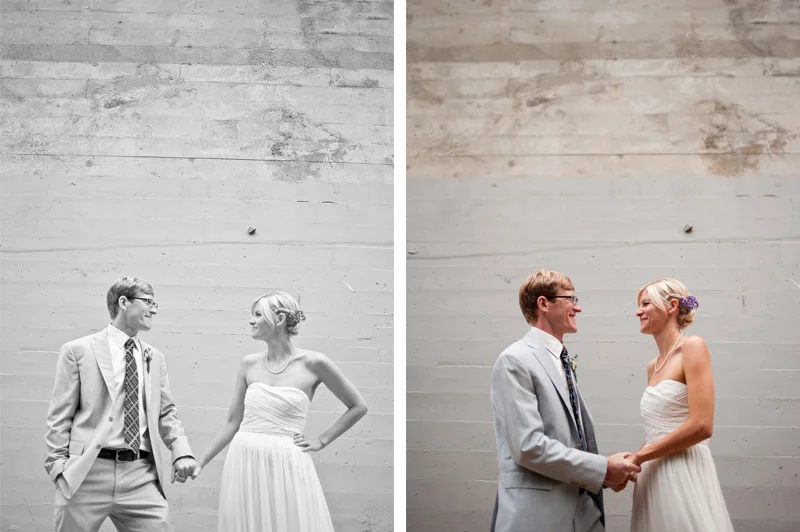 Bride and groom holding hands against grey wall in Oakland, CA