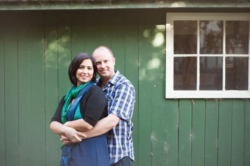 Couple in front of rustic green wood wall in San Francisco