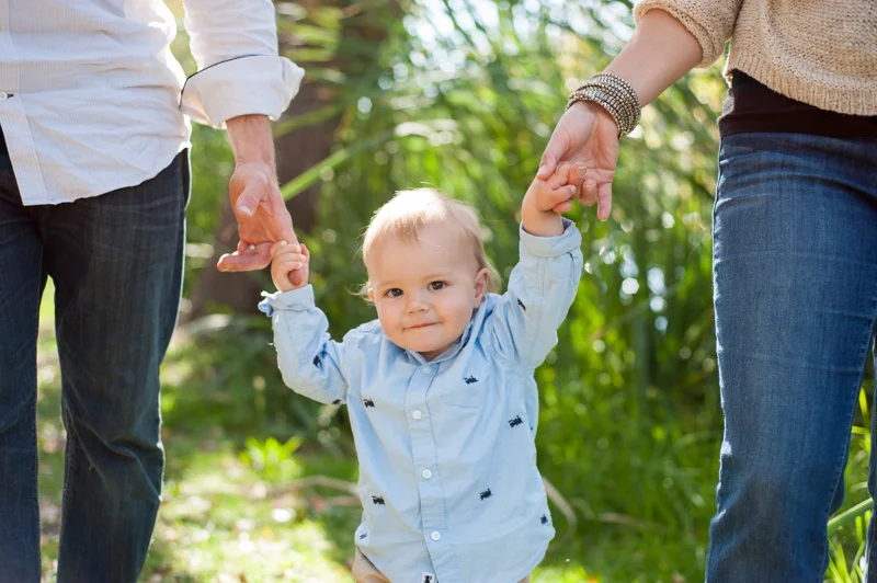 Little boy holding parents hands in Oakland