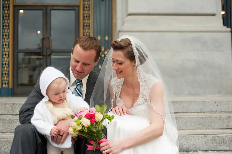 Bride and Groom on the steps of San Francisco with their daughter