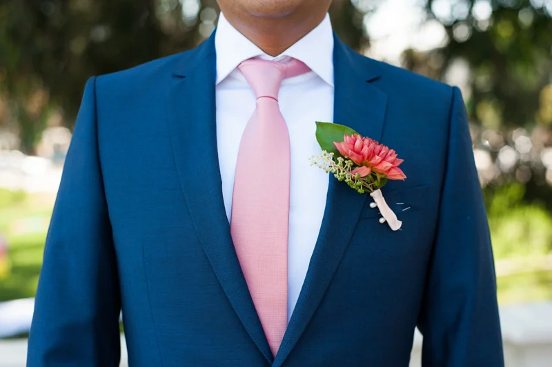 Detail of Groom's blue suit with pink tie