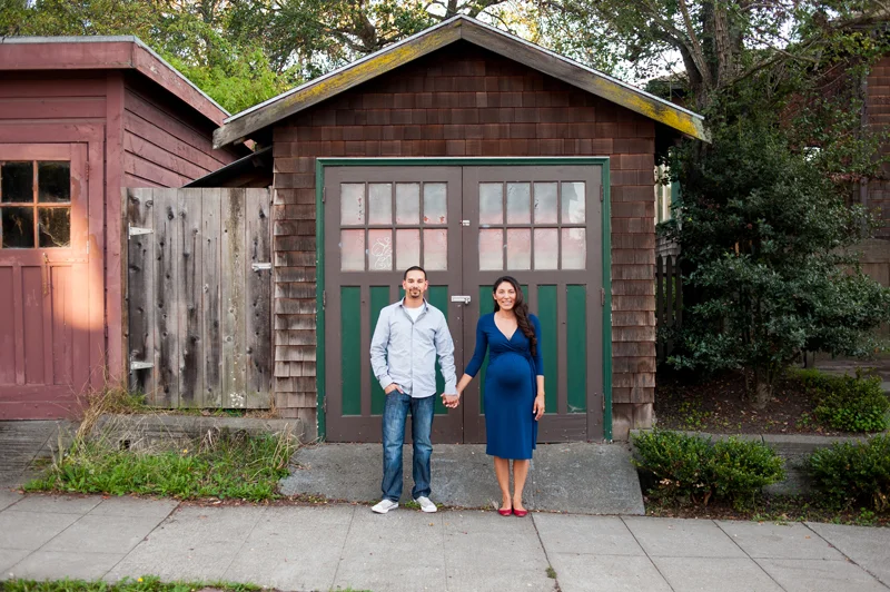 Pregnant couple in front of rustic doors