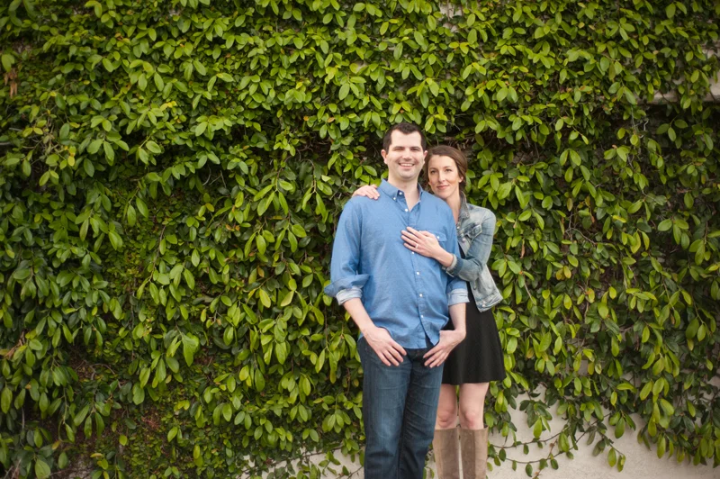 Engaged couple in front of natural wall