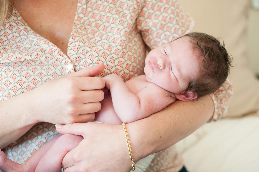 Newborn baby sleeping in mothers arms in Orinda, CA