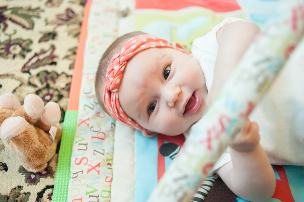 Baby girl playing on play mat