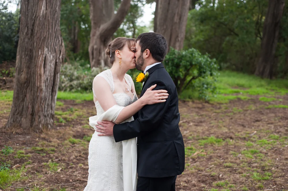 Bride and groom kiss before wedding ceremony in Golden Gate Park