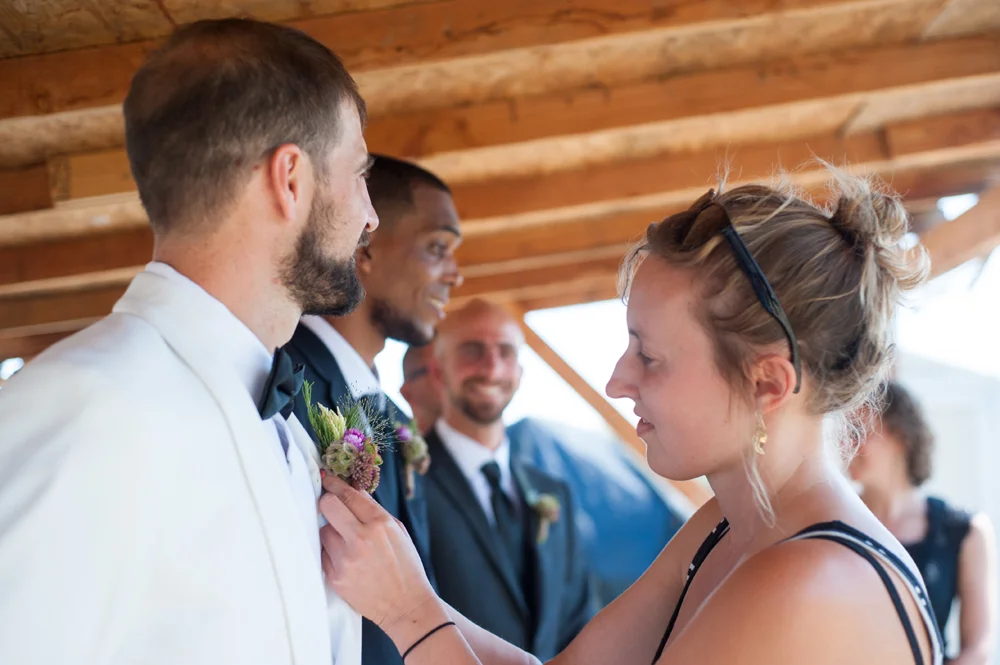 Groom having his boutonniere applied