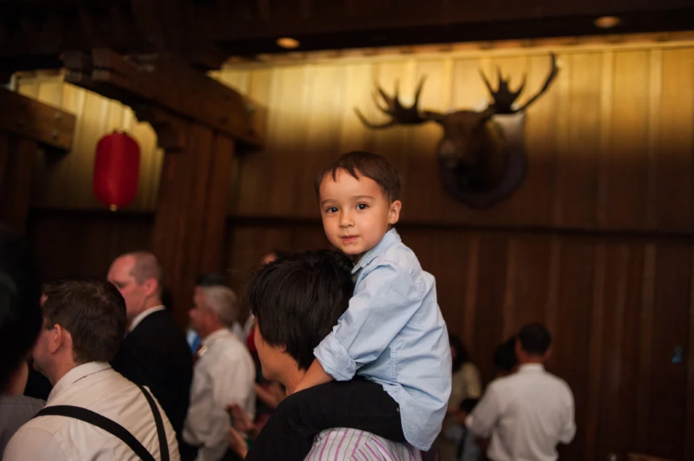 Candid photo of kid up on parents shoulders