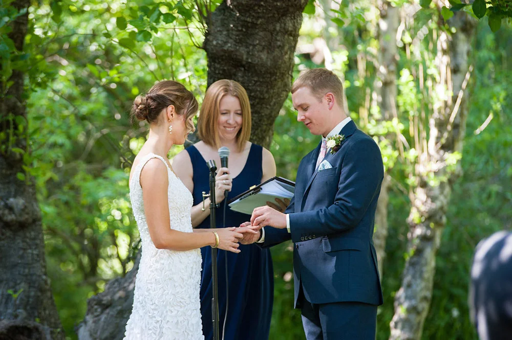 Groom placing wedding ring on Bride's finger