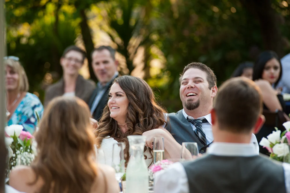 Candid portrait of bride and groom listening to toasts at Rancho Soquel