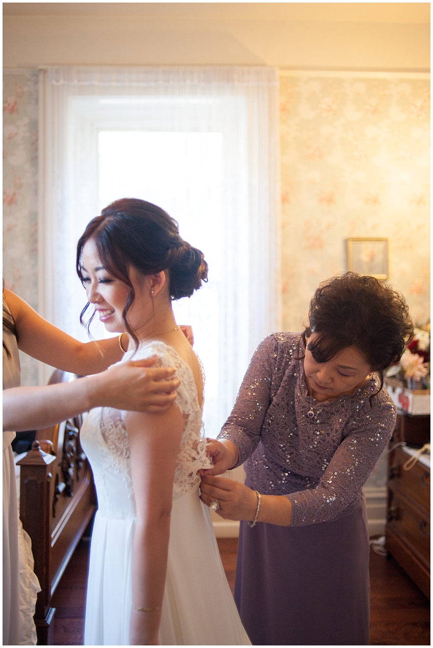 Mother of Bride helping Bride into wedding dress at Elliston Vineyards