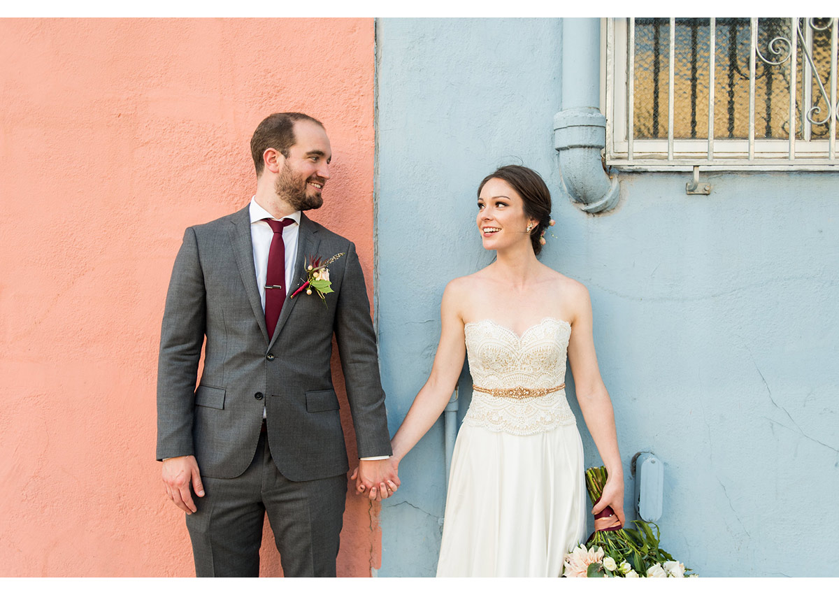 Bride and Groom in front of pink and blue wall in San Francisco