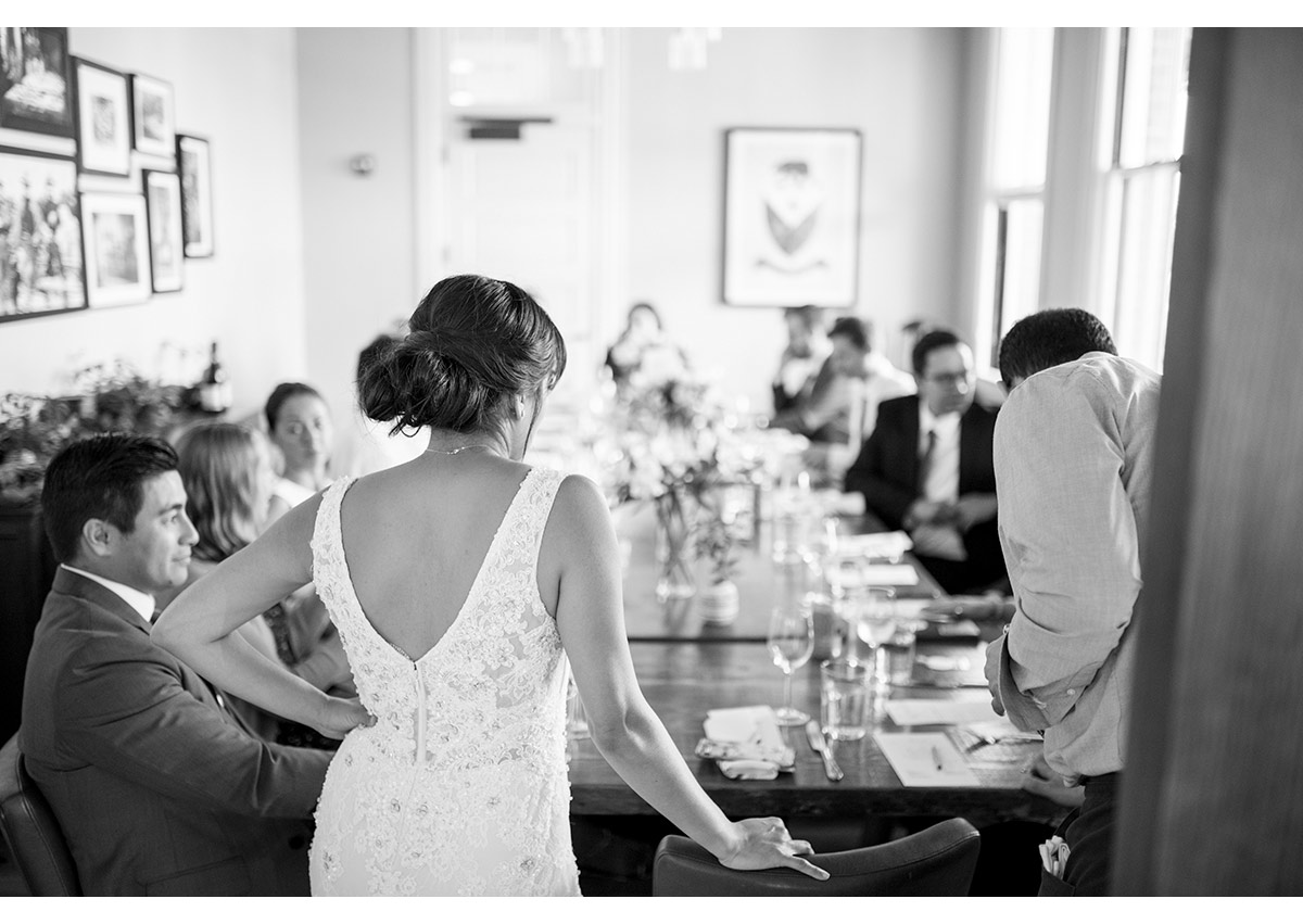 Candid of Bride standing at head of wedding table