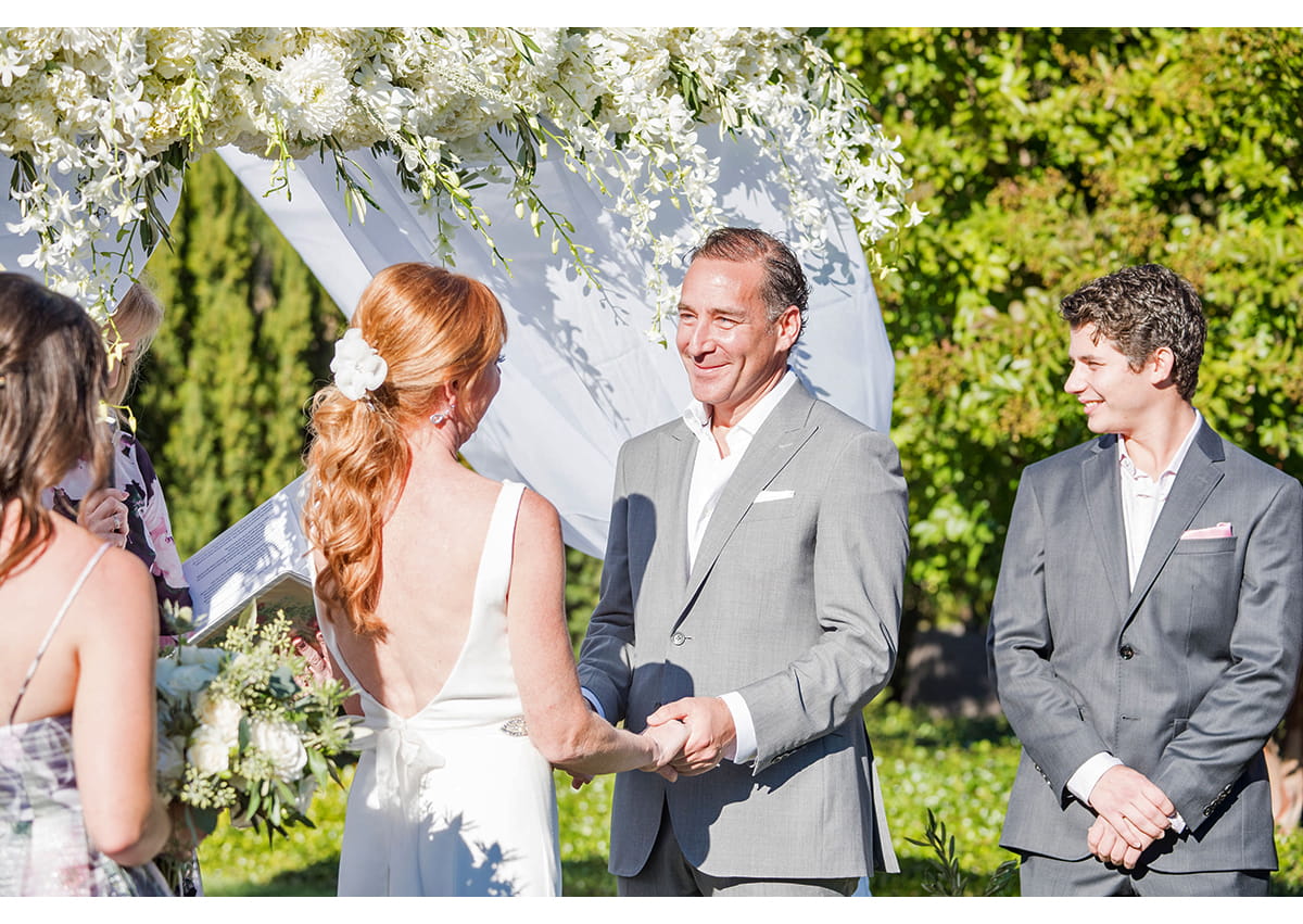 Groom holding Brides hands during wedding ceremony