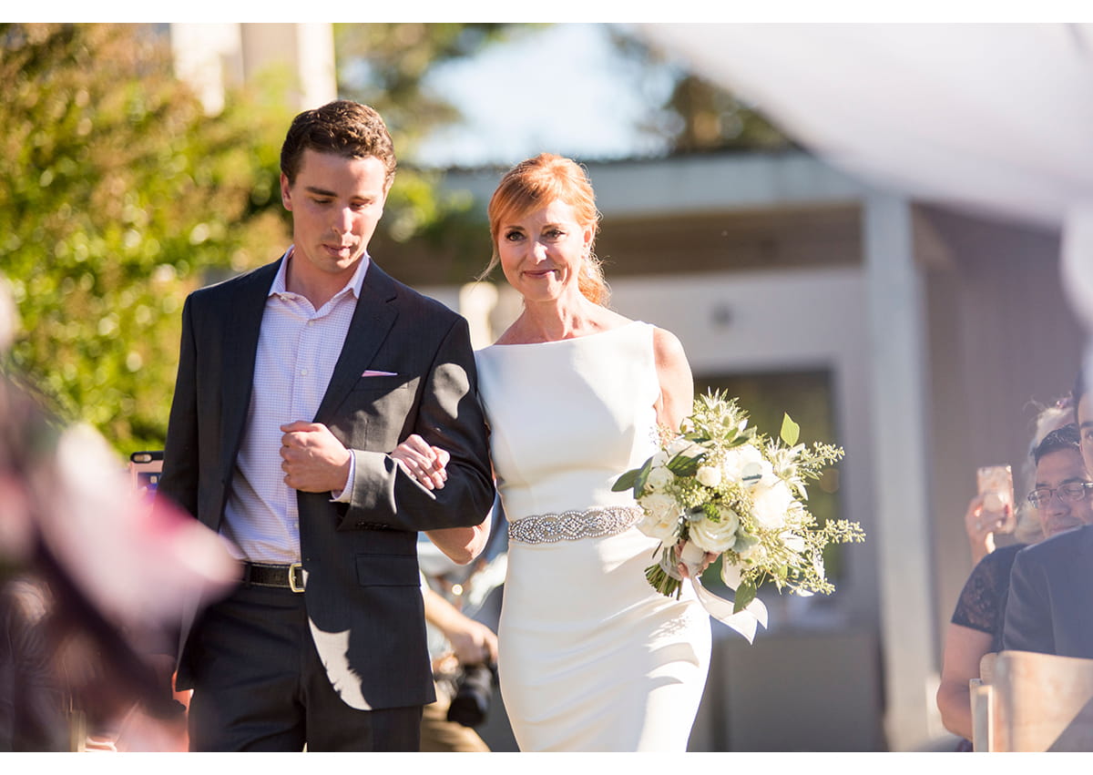 Bride walking down aisle with step son