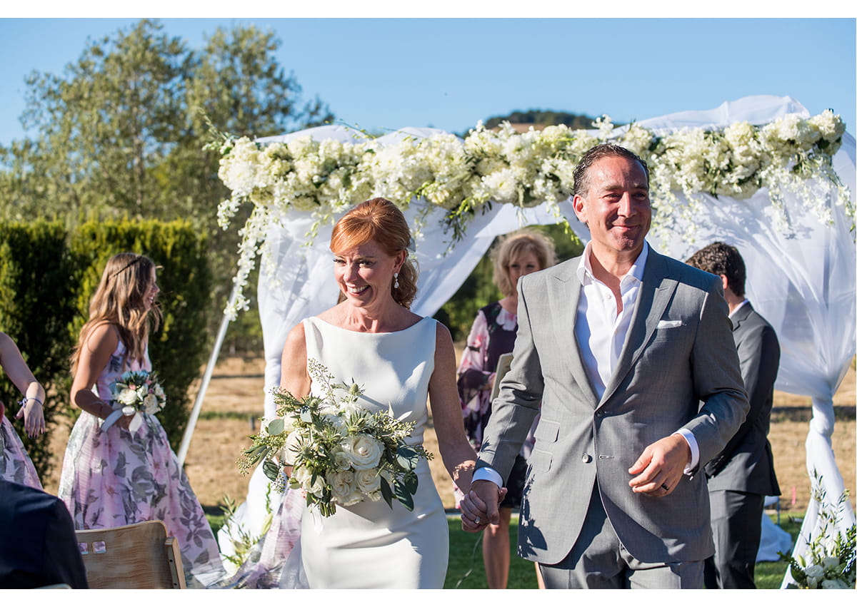 Bride and Groom walking down aisle smiling