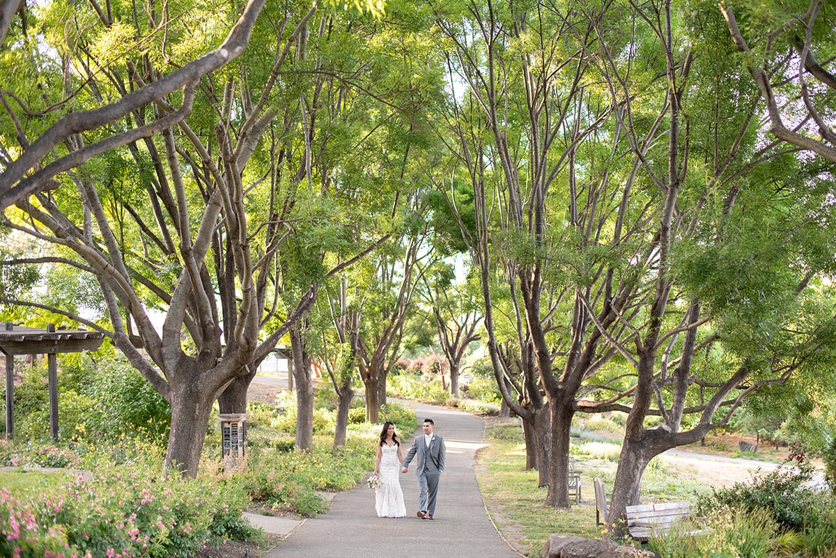 Bride and Groom walking along tree lined path at Heather Farm in Walnut Creek