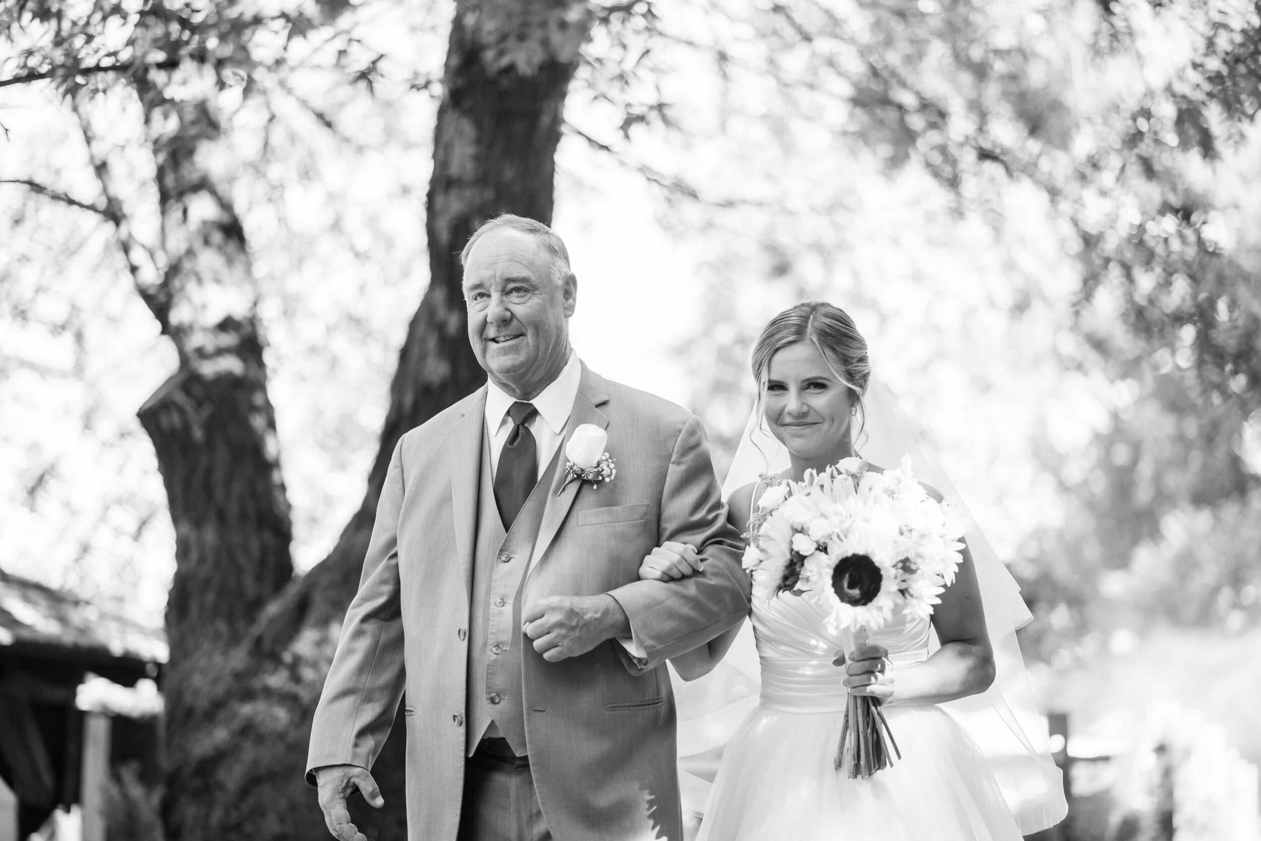 Black and white of bride and father walking to ceremony