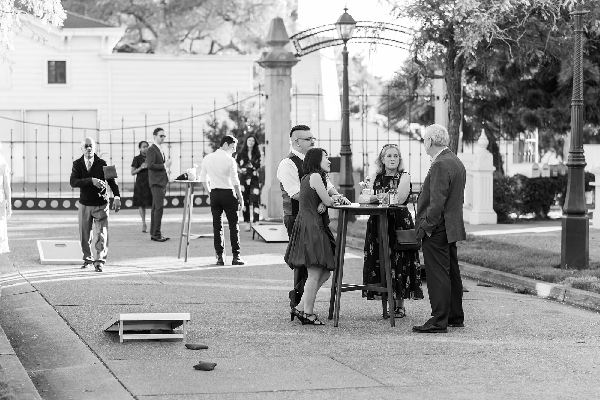 Black and white of wedding guests playing games during cocktail hour
