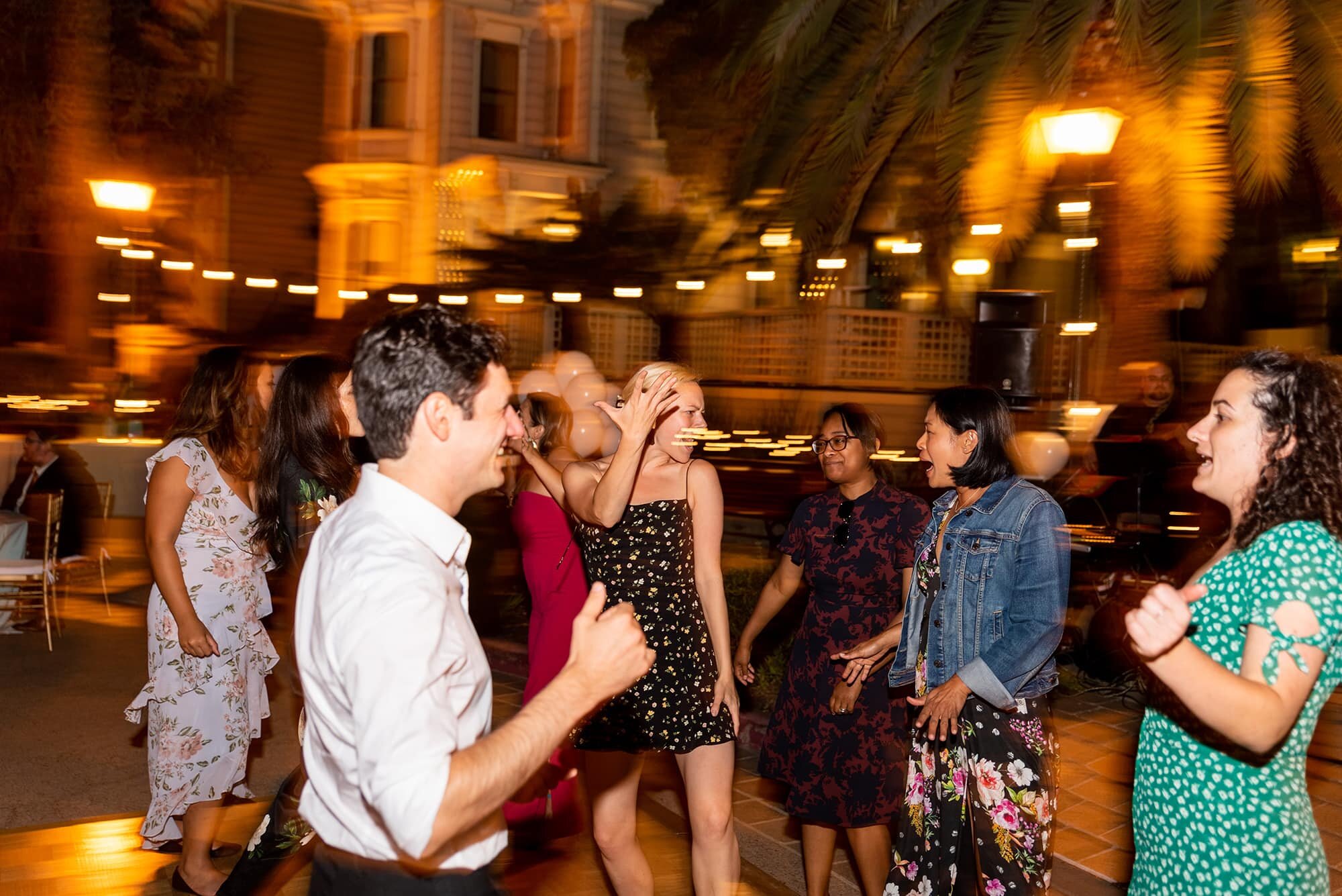 Candid photo of wedding guests dancing with motion blur