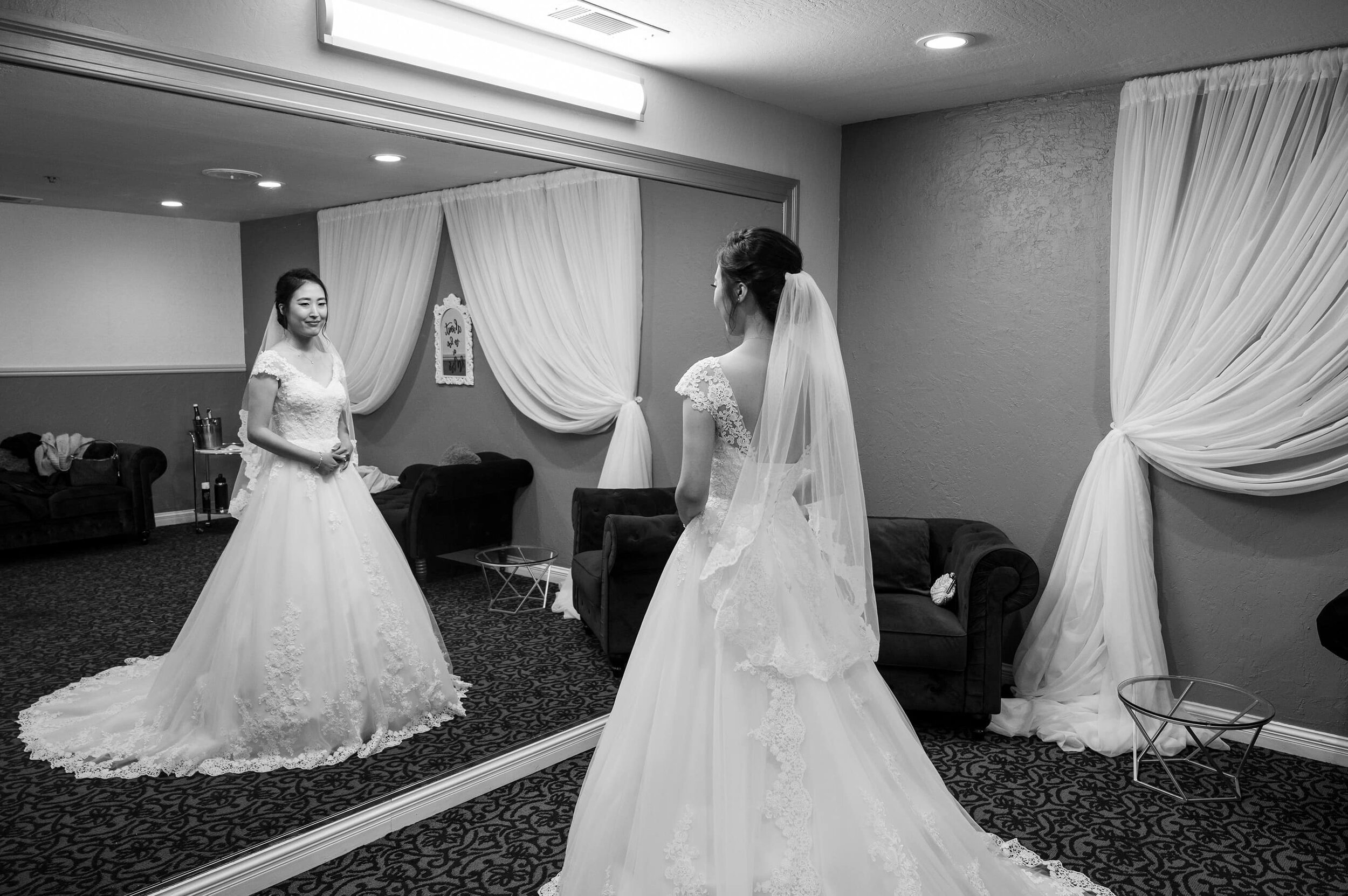 Bride looking in full length mirror in San Ramon Waters bridal suite