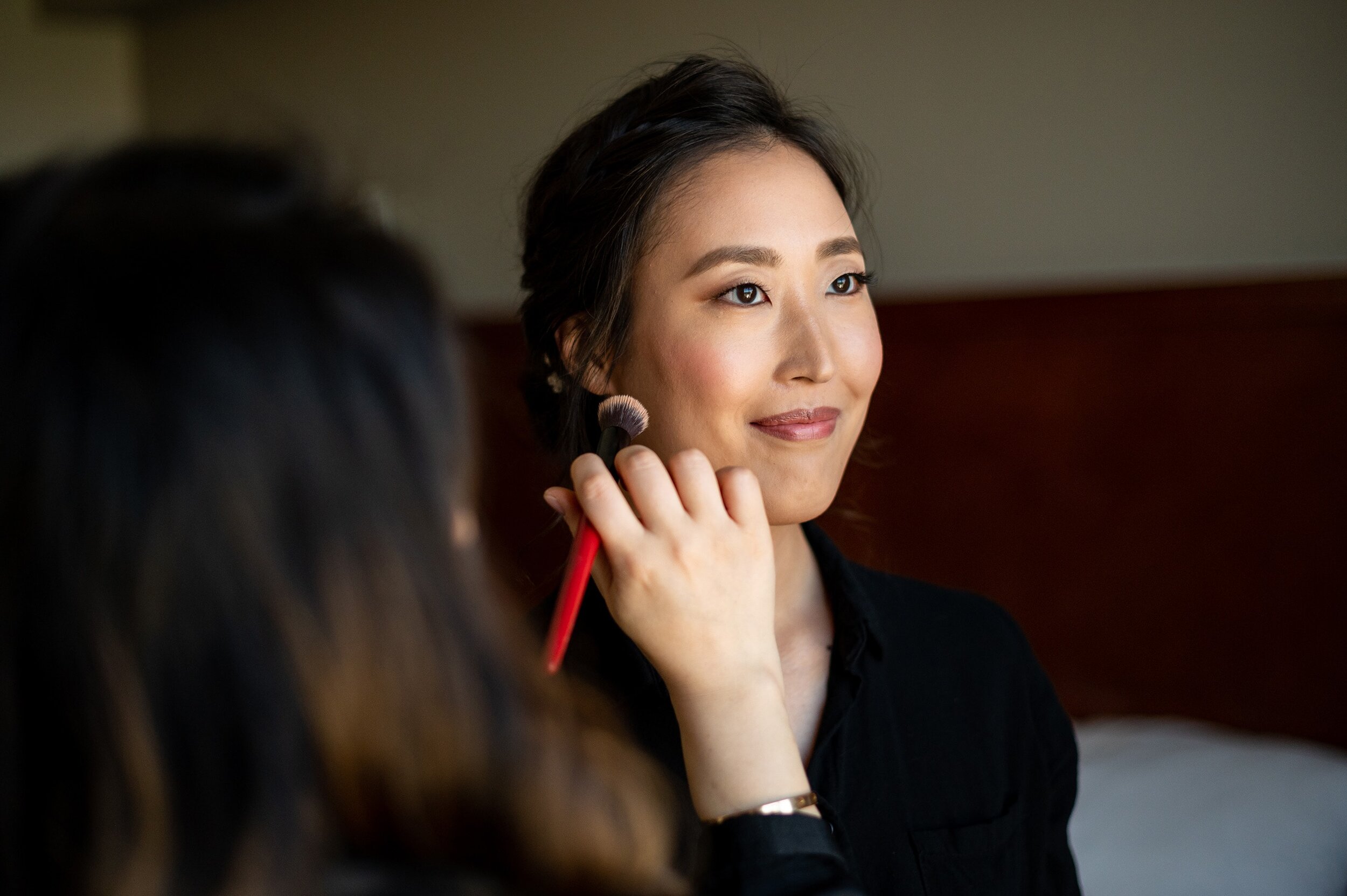 Portrait of bride getting make up done before wedding