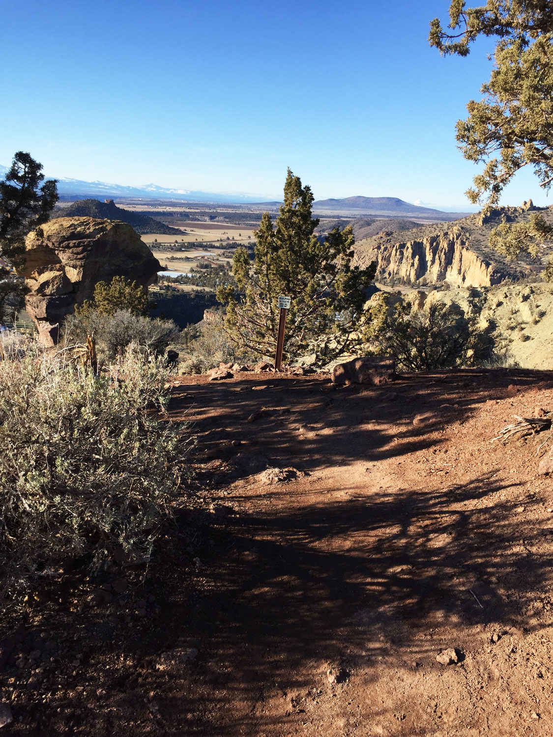 Just past a bench with a great view lurks the top of Monkey Face on the Misery Ridge Trail at Smith Rock State Park. A sign points to the continuation of the trail to descend to the Monkey base.