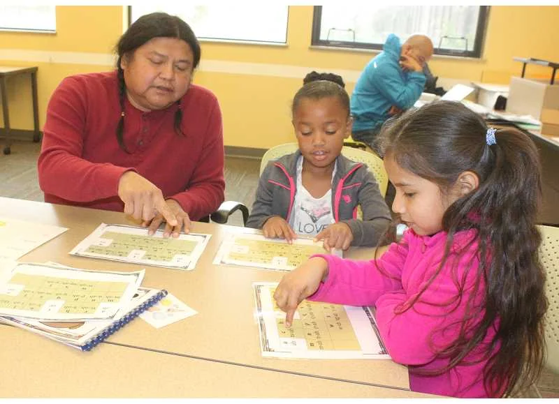 Dallas Winishut goes over Ishishklin (Wasco) alphabet with Warm Springs K-8 Academy first graders. Photo courtesy of the Portland Tribune.