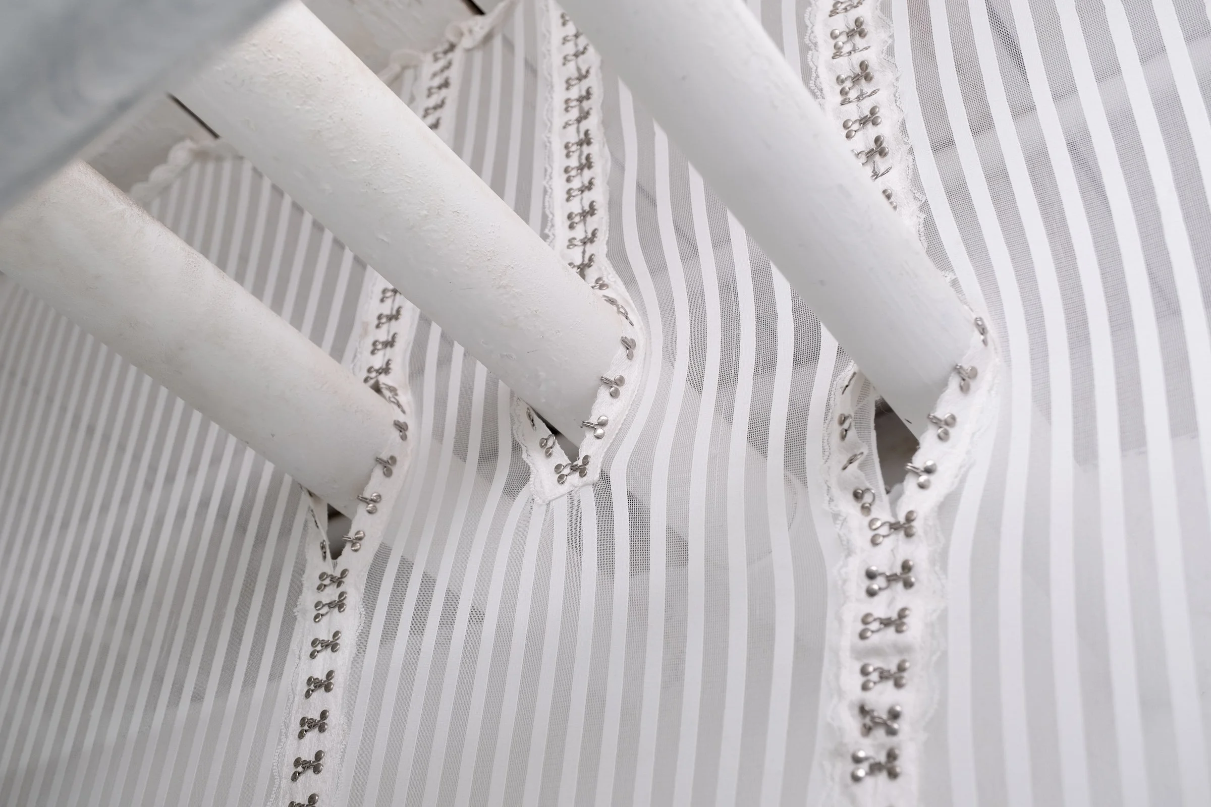   Bodice for Lyonya, Fedya, Katya and Vinny                                       2025. Site-specific installation with spandex mesh, linen, shelves, kettle bells, door draft stoppers, trim, linen thread, fabric polymer, ceramic, zip ties, oil paint,