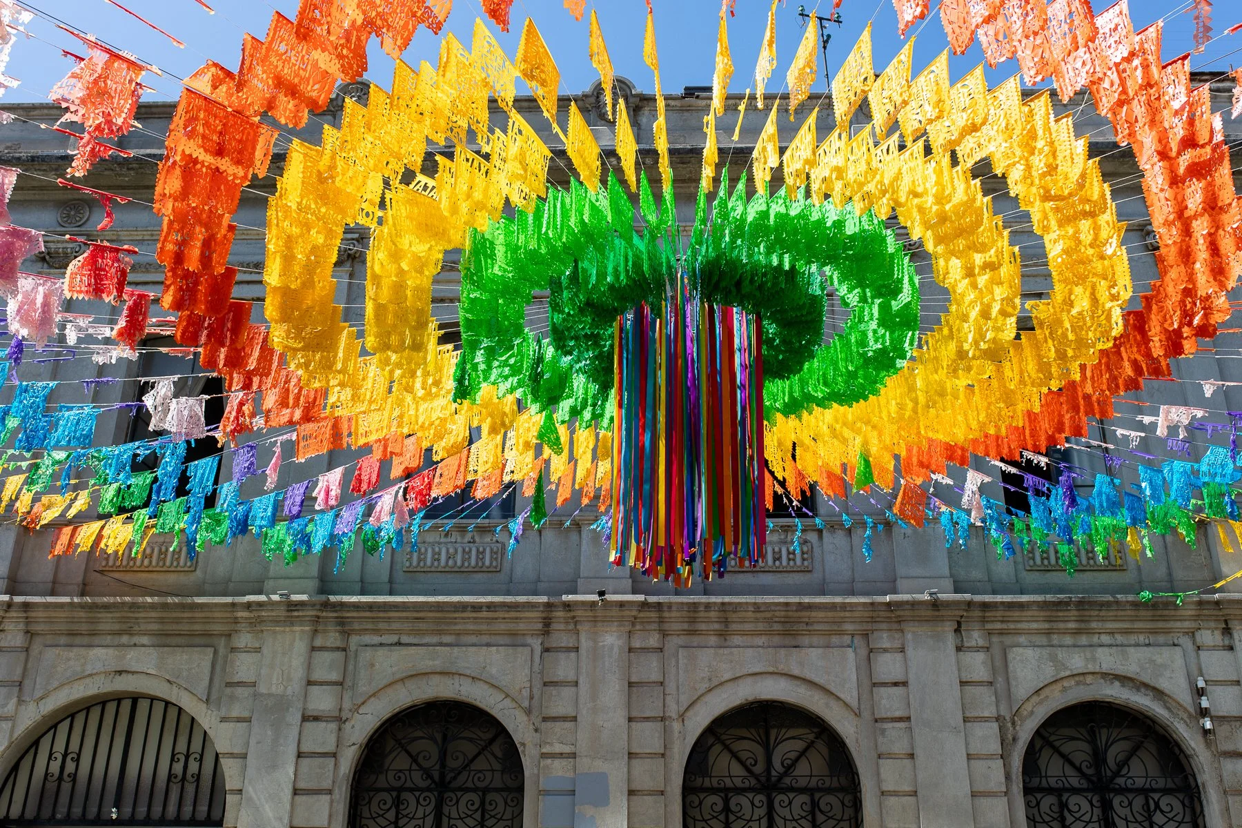 Colorful flags hanging above a street