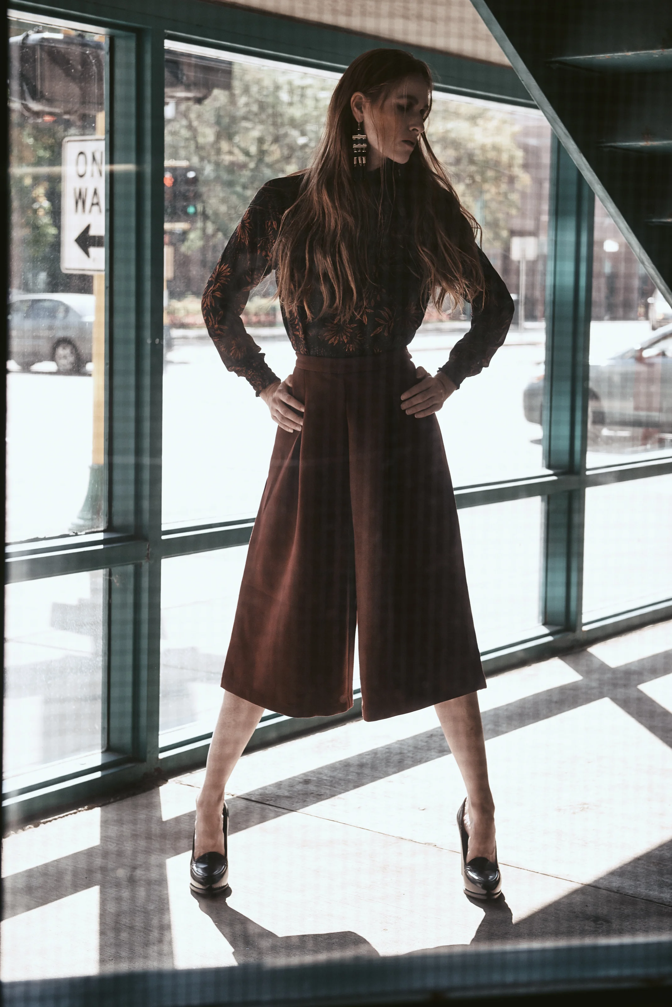  Twin Cities fashion styling featuring woman in palazzo pants and flowing blouse framed in architectural doorway 