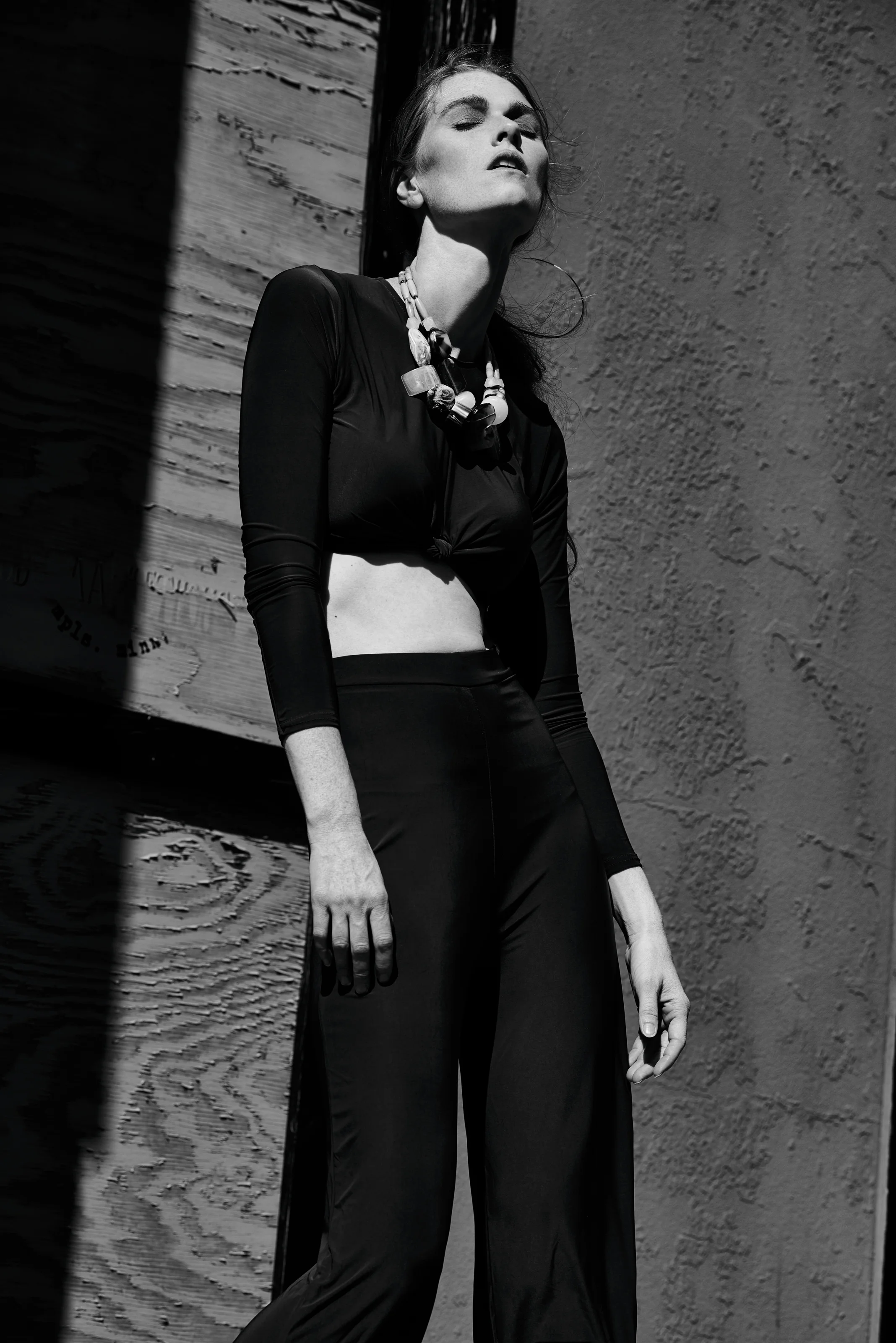  St. Paul editorial styling by Kate Moroney featuring black and white image of woman in structured two-piece set leaning against wall 