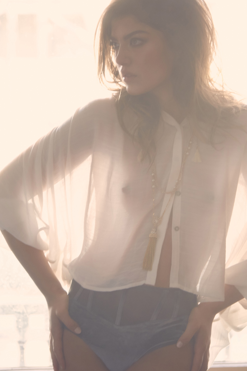  New York wardrobe stylist and personal stylist Kate Moroney featuring model in white top and briefs standing in window with soft, natural light and minimal styling 